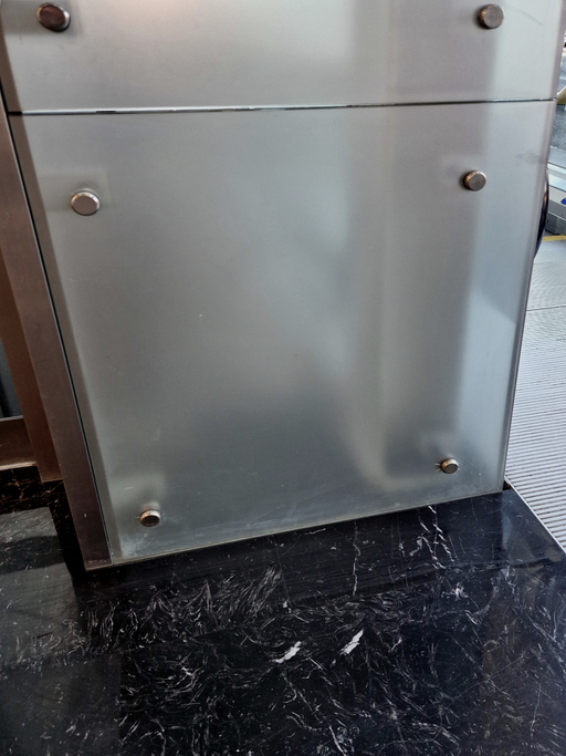 the glass is attached to the wall using screws and washers intended for drilling into glass. the cladding is a railing and an air partition in the station hall